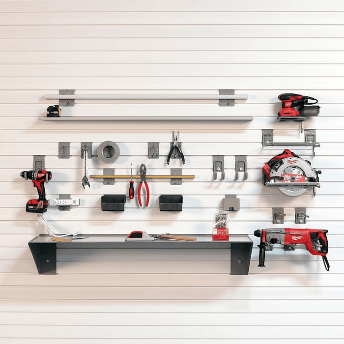 StoreWALL white slatwall panel system loaded with Milwaukee power tools, hand tools, drill bits, and a steel shelf -- showing hooks, bins, and accessories organized across the full wall