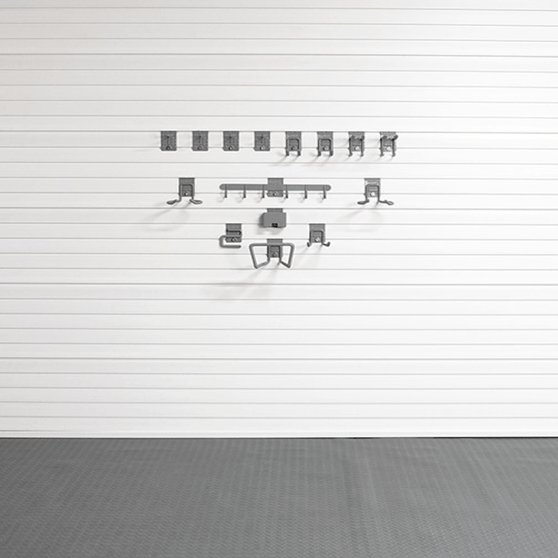 A set of gray metal wall-mounted hooks or hangers arranged in rows on a white paneled wall above a gray floor.