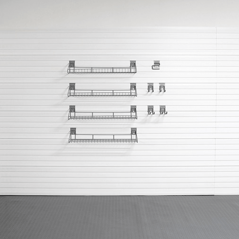 Four black metal wire shelving units of varying lengths mounted on a white paneled wall, with a gray floor below.