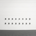 A set of twelve dark gray metal garage door hooks arranged in two rows of six on a white slatted garage door, with a dark textured floor below.