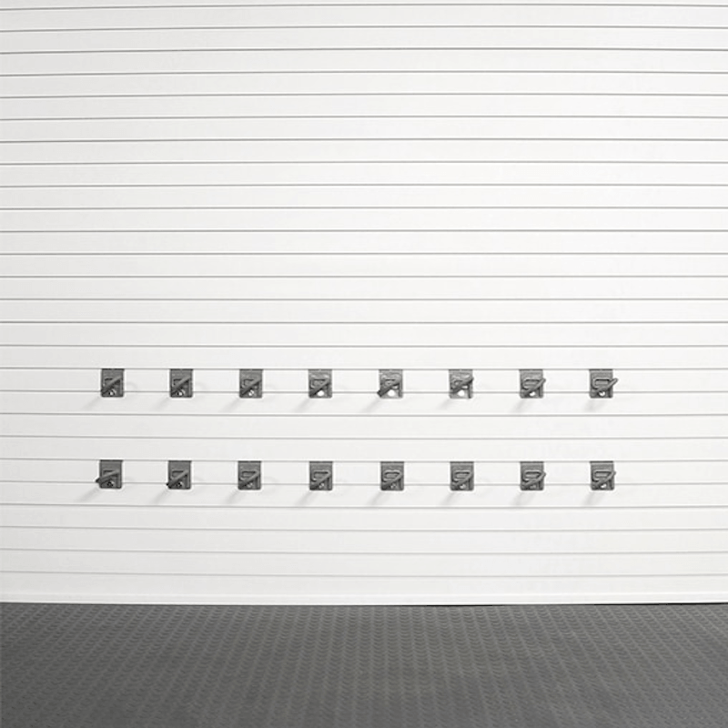 A set of twelve dark gray metal garage door hooks arranged in two rows of six on a white slatted garage door, with a dark textured floor below.