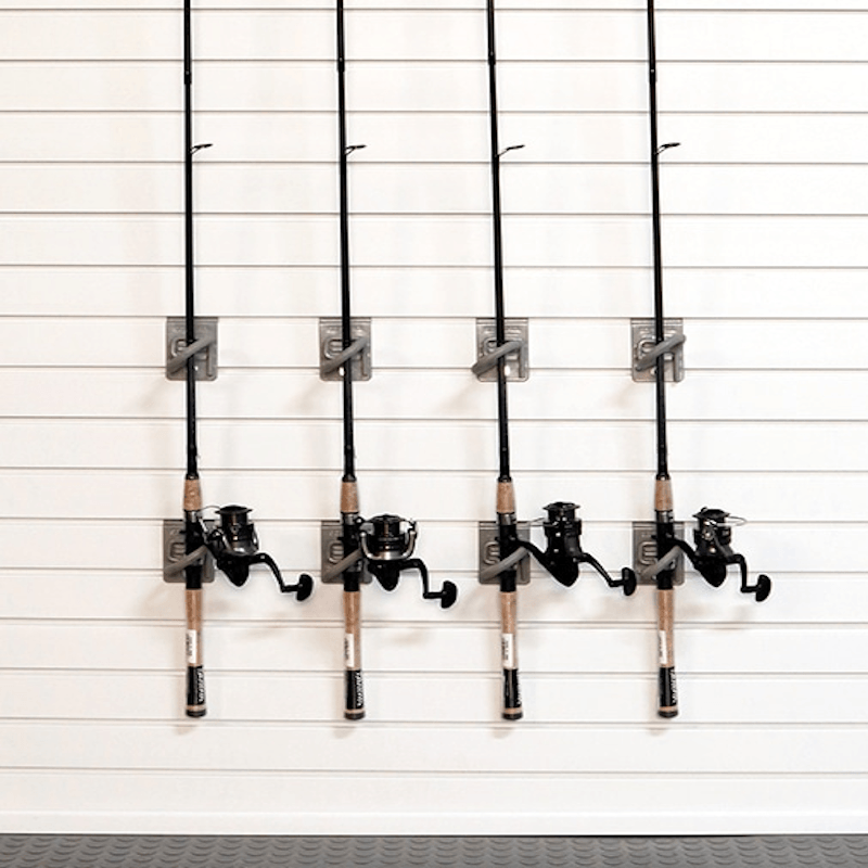Four fishing rods with black reels mounted on a white slatwall storage system.