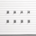 Six gray plastic garage door hooks arranged in two rows of three on a white slatted garage door, with a gray textured surface visible along the bottom edge.