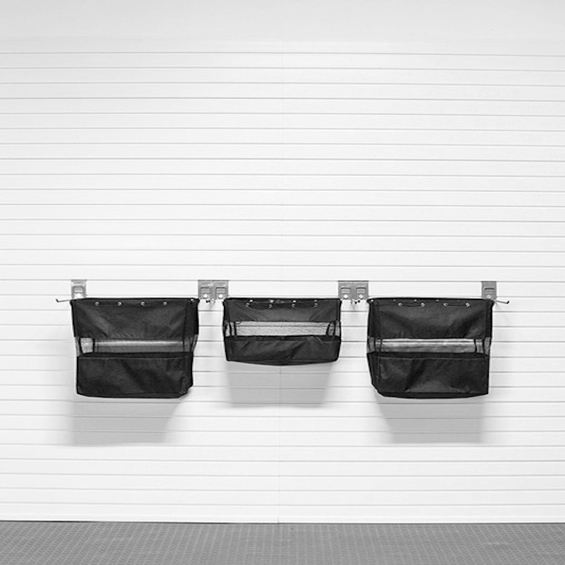 Three black mesh hanging utility pouches mounted on a white paneled wall with metal brackets.