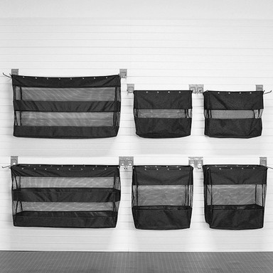 Set of six black mesh storage bags hanging on a white wall.