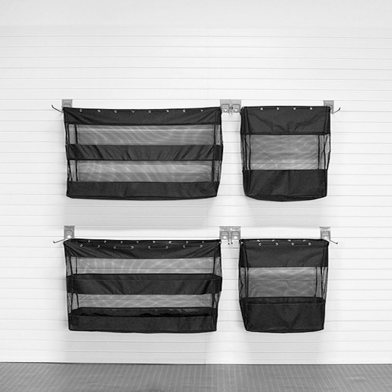 Four black mesh hanging organizer pockets with metal clips, arranged in a 2x2 grid on a white paneled wall.