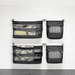 Four black mesh hanging organizer pockets mounted on a white paneled wall, each holding folded bedding or striped fabric items.