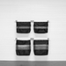 Four black mesh hanging storage bags with metal clips, arranged in a 2x2 grid on a white paneled wall.