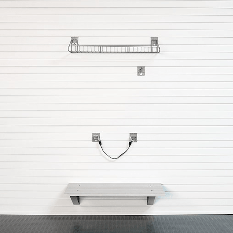 A wall-mounted metal wire shelf and a matching horizontal shelf rail with wall brackets, shown against a white paneled wall above a dark floor.