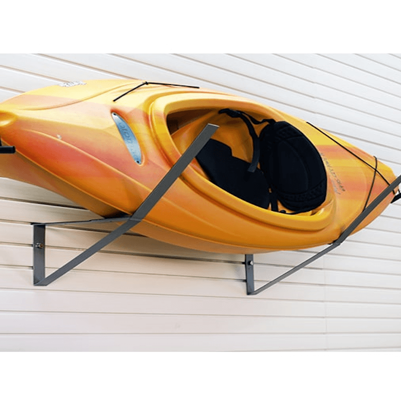 A yellow and orange kayak mounted on a black metal wall rack against a white siding wall.