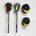 Two lacrosse sticks with attached lacrosse heads and two black lacrosse helmets with yellow accents, mounted on a white slatted wall.