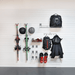 A wall-mounted ski rack system holding skis, helmets, backpacks, a jacket, and ski boots against a white slatted wall.