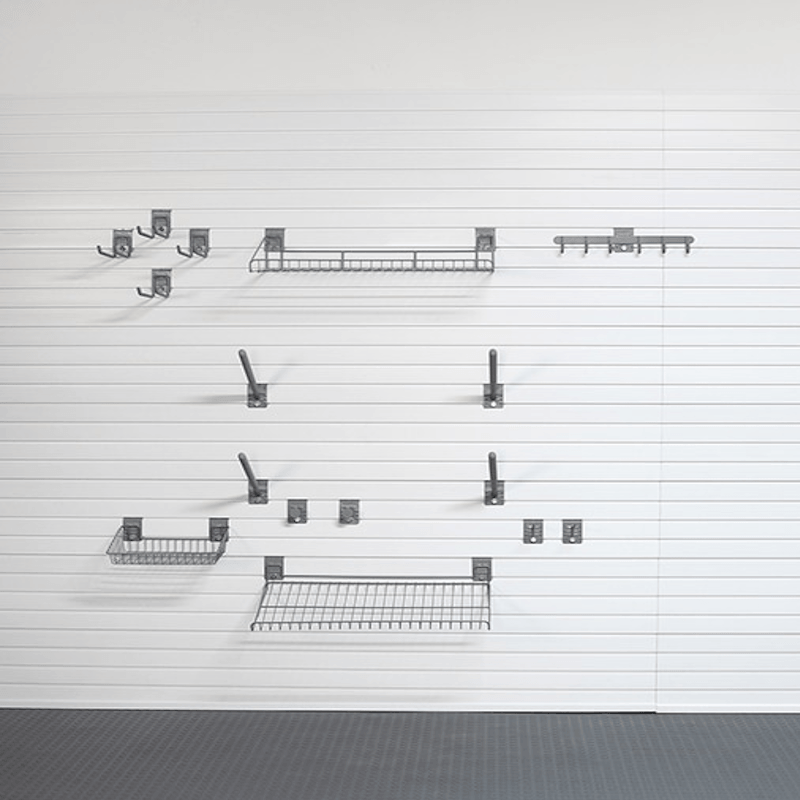 A set of dark gray metal wall-mounted storage shelves and hooks arranged on a white paneled wall above a dark gray floor.