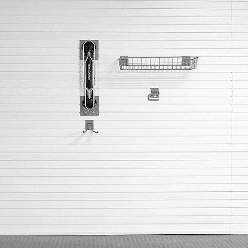 A garage door opener and matching wall-mounted storage accessories shown against a white garage door with horizontal panel lines.