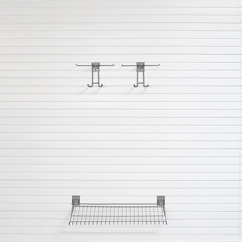 A wall-mounted metal wire shelf and two matching hanging hooks on a white paneled wall.