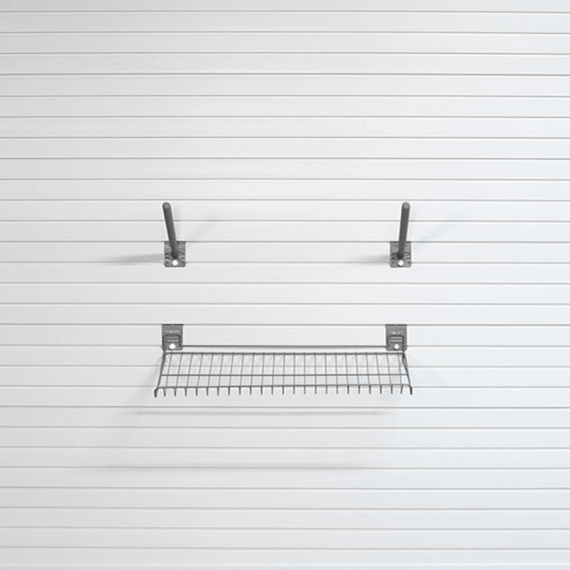 A metal wire shelf with two wall mounting brackets, shown against a white slatwall background.