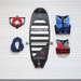 A HYPERLITE wakeboard or ski board is mounted on a white slatted wall, flanked by accessories: a red and black grab handle, a blue rope, and two life vests in blue and red-gray.