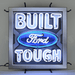 Neonetics Built Ford Tough neon sign featuring blue and white hand-blown glass neon over a full-color logo background.