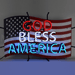 Neonetics God Bless America neon sign with patriotic red, white, and blue hand-blown glass neon over a waving flag background.