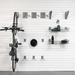 Staged vertical storage solution using J Hooks, showing the mounted bike alongside a floor pump and helmet on the slatwall.