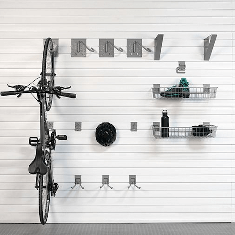 Staged vertical storage solution using J Hooks, showing the mounted bike alongside a floor pump and helmet on the slatwall.
