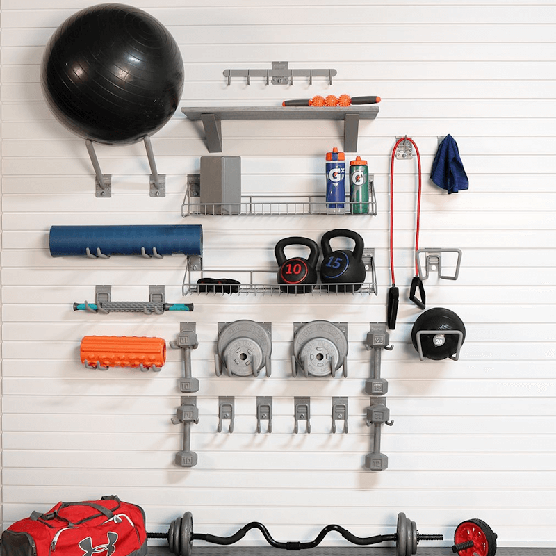 Clean, organized workout space using the Premium Bundle's heavy-duty hooks to store resistance bands, sneakers, and exercise balls on the slatwall.