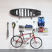 Tidy sports gear station utilizing the Select Bundle, displaying a bike helmet, pump, and cycling shoes organized on a central wall section.